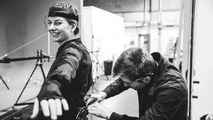 Technician fitting a motion-capture suit on a performer