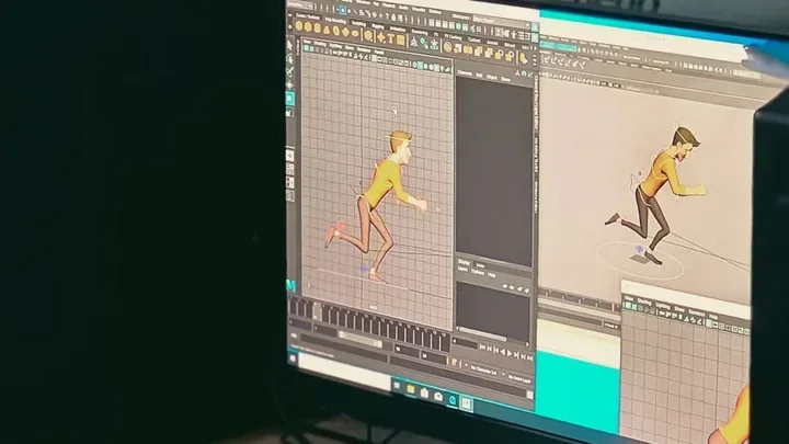 Animation workstation with a character on screen and drawings on the desk